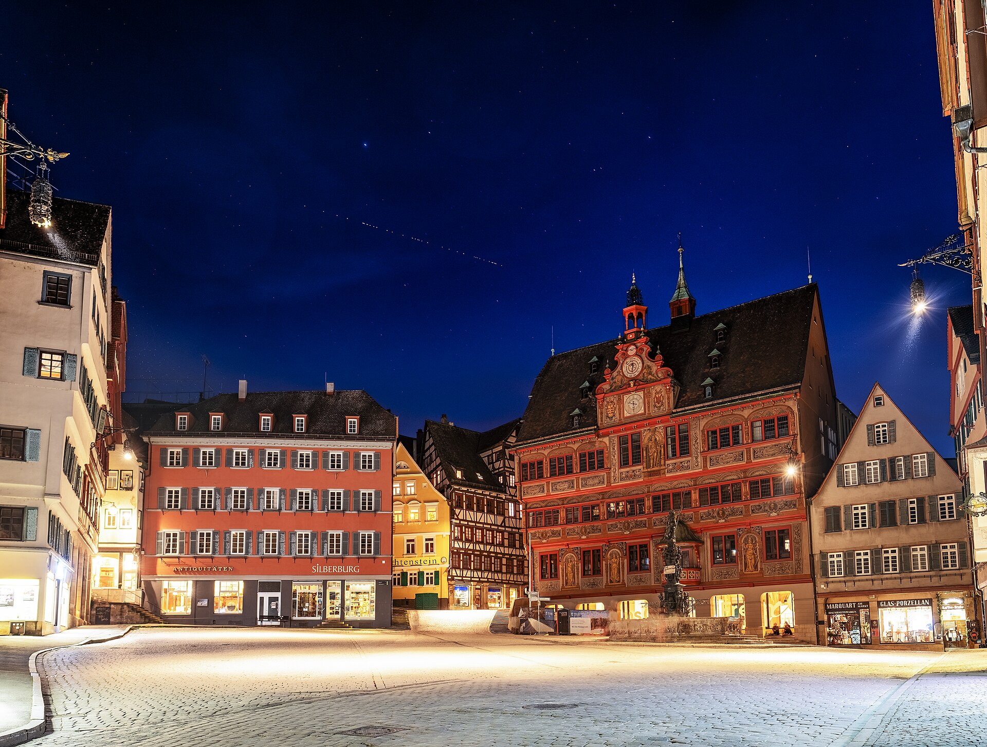 Nächtlicher Marktplatz in Tübingen mit einer Starlink-Kette am Himmel